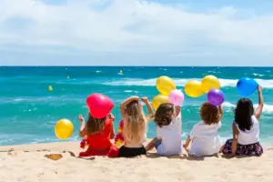 Children sitting on beach with color balloons. children engaged in storytelling, developing language and imagination