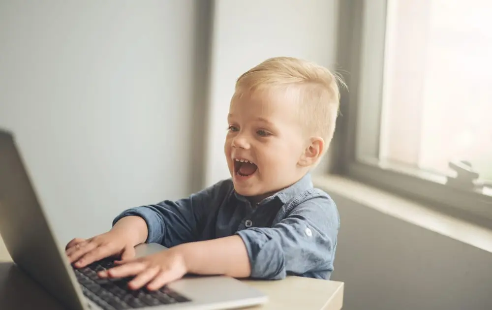 Child playing on laptop a toddler focused on developing fine motor skills with sorting activities